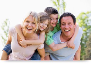 Family of four smiling and happy posing with children.