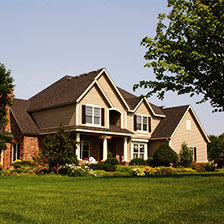 Brick and tan home with landscaped front lawn
