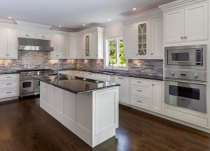 A newly constructed home with a beautiful kitchen. hardwood floors, tile backsplash, an island, two ovens and sinks as well as an incredible view.